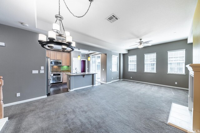 1785 Wind Ranch Rd Unit C, Reno, NV 89521 - unfurnished living room with dark carpet, ceiling fan, a chandelier, baseboards, and a sink