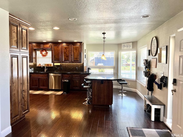 310 N Mountain View St, Yerington, NV 89447 - kitchen with dishwasher, a textured ceiling, a breakfast bar, dark wood finished floors, and baseboards