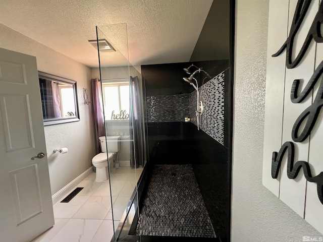 310 N Mountain View St, Yerington, NV 89447 - full bath with tiled shower, toilet, baseboards, marble finish floors, and a textured ceiling