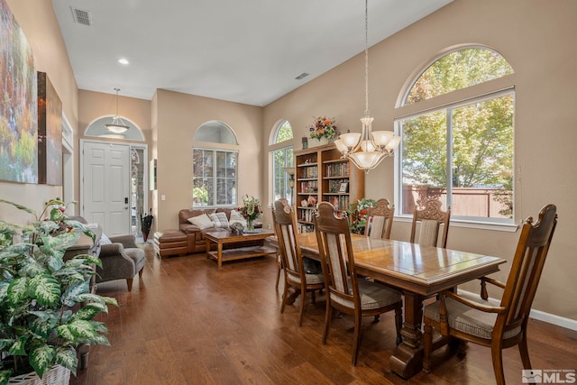 10710 Ivy Gate, Reno, NV 89521 - dining area featuring a chandelier, a towering ceiling, dark wood-type flooring, and baseboards