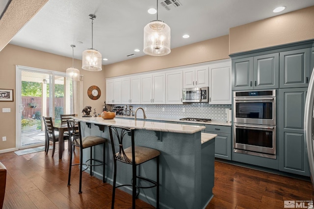 10710 Ivy Gate, Reno, NV 89521 - kitchen with appliances with stainless steel finishes, tasteful backsplash, light stone countertops, dark wood-style flooring, and recessed lighting