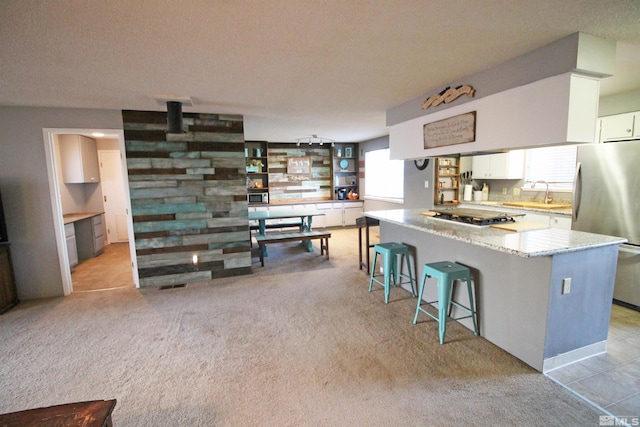 27 Amanda Cir, Sparks, NV 89436 - kitchen with appliances with stainless steel finishes, white cabinets, a sink, light stone countertops, and a breakfast bar