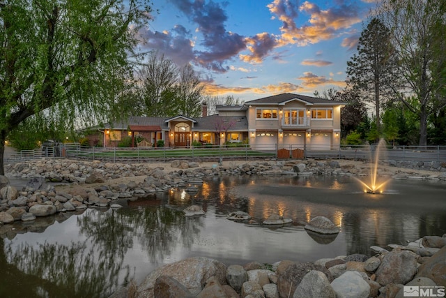 1865 Olive Ln, Reno, NV 89511 - back of property at dusk with an attached garage, fence, a water view, and a balcony