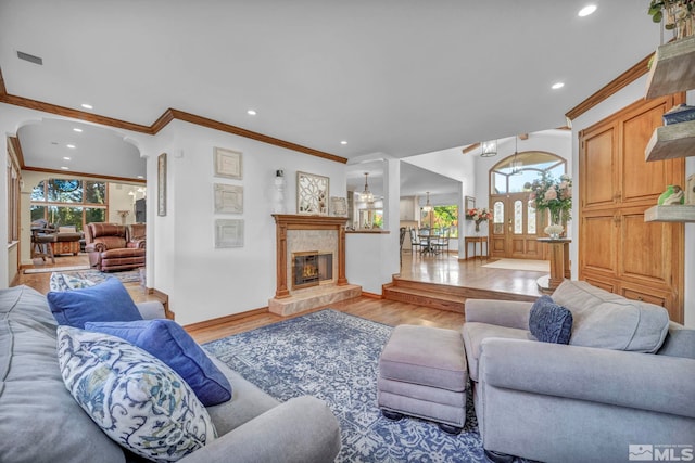 1865 Olive Ln, Reno, NV 89511 - living area with light wood-type flooring, crown molding, recessed lighting, arched walkways, and a tiled fireplace