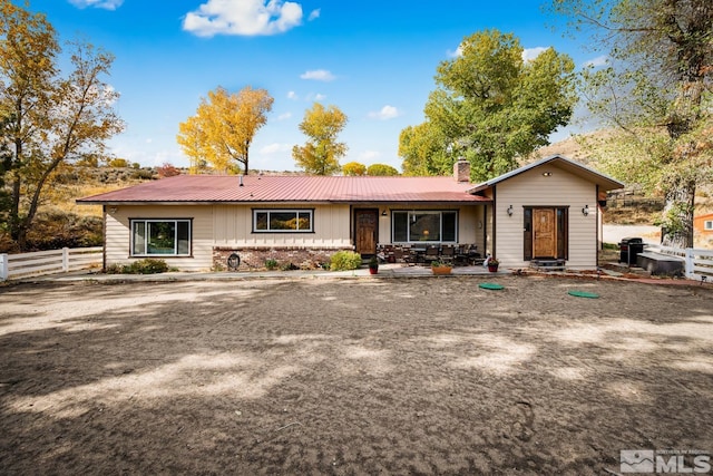 14005 N Red Rock Rd, Reno, NV 89508 - view of front of home featuring fence, a chimney, and metal roof