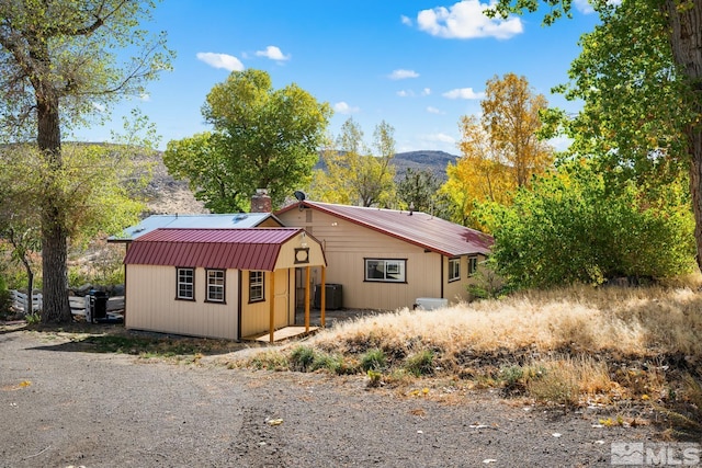 14005 N Red Rock Rd, Reno, NV 89508 - view of front of home featuring a mountain view, metal roof, an outbuilding, and central air condition unit