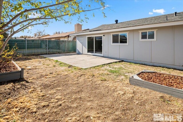 630 Teel St, Sparks, NV 89431 - back of property with a patio area, a fenced backyard, board and batten siding, and a chimney