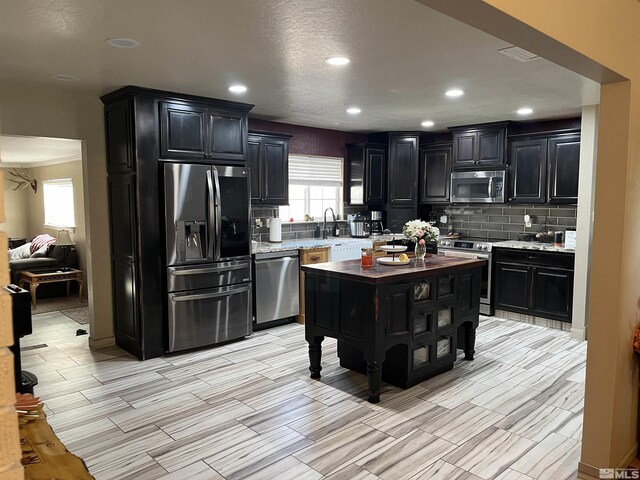 3205 Saint Clair Rd, Fallon, NV 89406 - kitchen featuring appliances with stainless steel finishes, dark cabinetry, tasteful backsplash, healthy amount of natural light, and recessed lighting