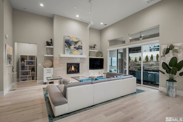 718 W Pleasant Oak Trl, Reno, NV 89511 - living area with a towering ceiling, wood finished floors, recessed lighting, a tiled fireplace, and baseboards