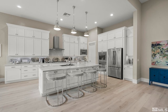 718 W Pleasant Oak Trl, Reno, NV 89511 - kitchen featuring wall chimney exhaust hood, high end fridge, a sink, a kitchen breakfast bar, and white cabinets