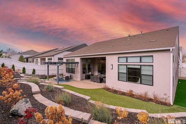 718 W Pleasant Oak Trl, Reno, NV 89511 - back of property at dusk featuring a patio area, an outdoor hangout area, stucco siding, and roof with shingles
