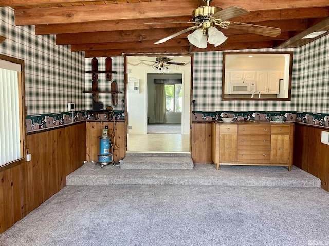 2 N Whitacre St, Yerington, NV 89447 - kitchen featuring wallpapered walls, beamed ceiling, white microwave, carpet flooring, and a ceiling fan