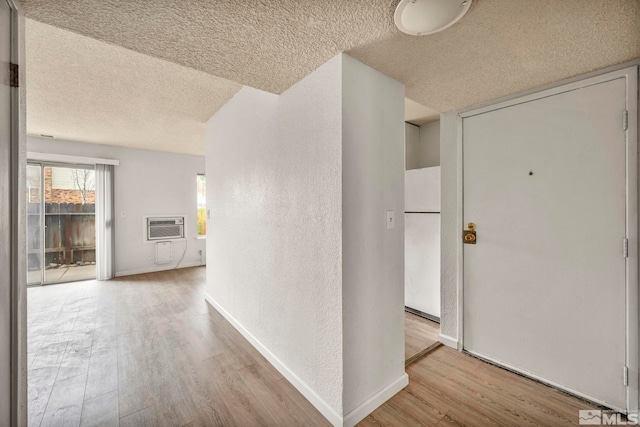 4608 Neil Rd Unit 241, Reno, NV 89502 - hall featuring a textured ceiling, wood finished floors, a wall mounted air conditioner, a textured wall, and baseboards
