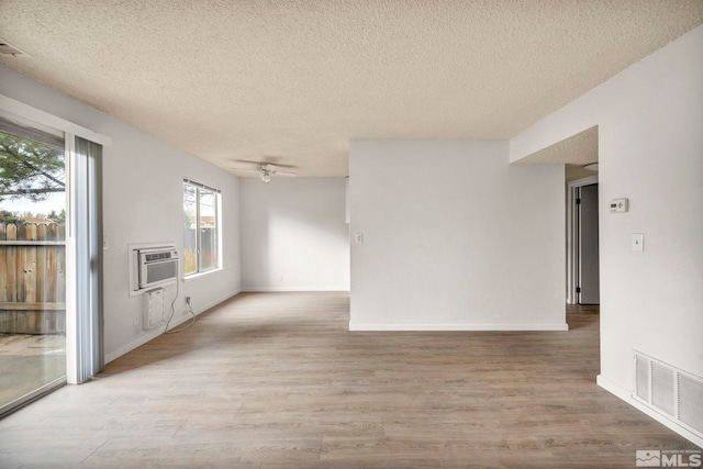 4608 Neil Rd Unit 241, Reno, NV 89502 - spare room with a textured ceiling, wood finished floors, ceiling fan, a wall mounted AC, and baseboards
