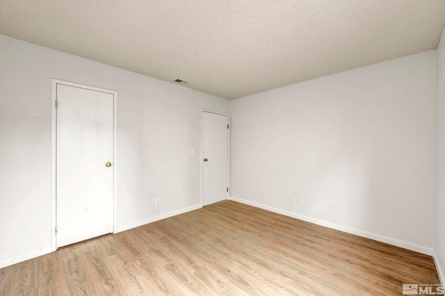 4608 Neil Rd Unit 241, Reno, NV 89502 - unfurnished bedroom featuring light wood-style flooring, baseboards, and a textured ceiling