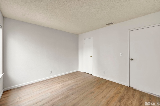 4608 Neil Rd Unit 241, Reno, NV 89502 - empty room with wood finished floors, a textured ceiling, and baseboards