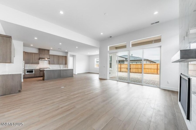 7511 Hoback Dr Unit Windsong 54, Sparks, NV 89436 - unfurnished living room with light wood-style floors, recessed lighting, and a fireplace