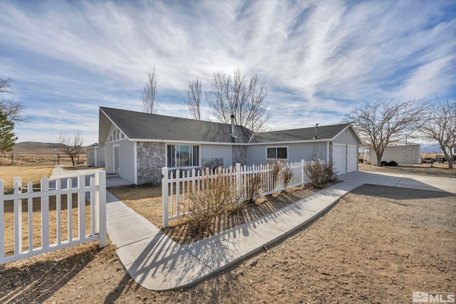 605 E US Highway 95a, Yerington, NV 89447 - ranch-style home with concrete driveway, a fenced front yard, stone siding, and a garage