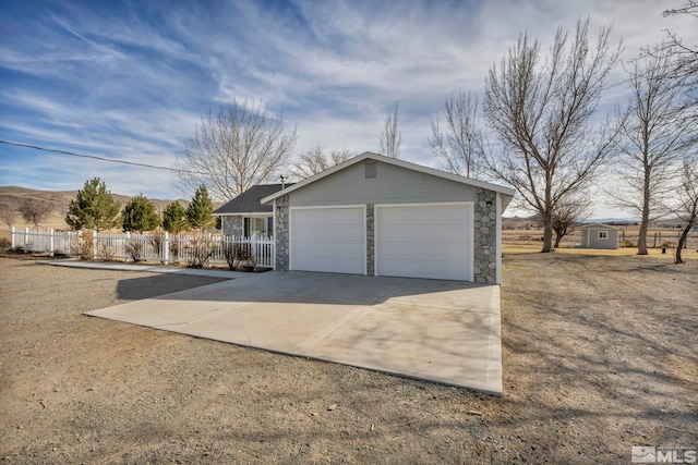605 E US Highway 95a, Yerington, NV 89447 - garage with fence, concrete driveway, and a storage shed
