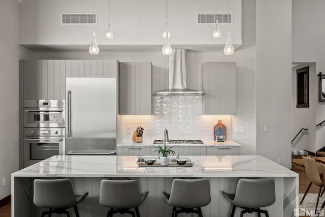 28 Beach Club Dr Unit 407, Stateline, NV 89449 - kitchen with wall chimney exhaust hood, appliances with stainless steel finishes, decorative backsplash, modern cabinets, and decorative light fixtures