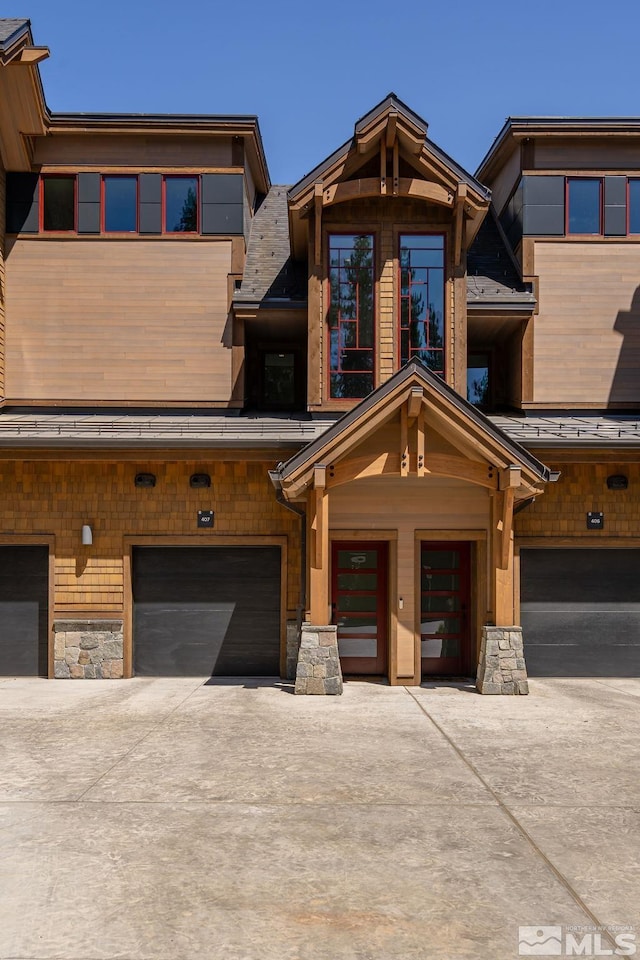 28 Beach Club Dr Unit 407, Stateline, NV 89449 - view of front of home featuring concrete driveway, an attached garage, and stone siding