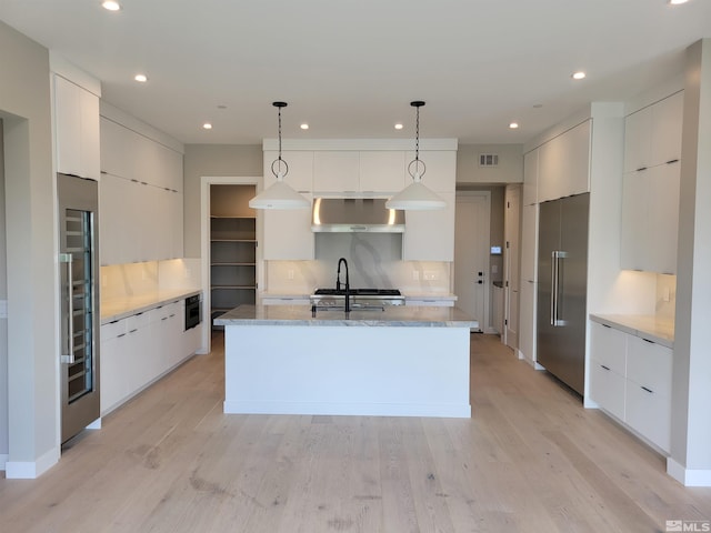 62 Caballada St, Reno, NV 89511 - kitchen with modern cabinets, high end refrigerator, exhaust hood, white cabinets, and an island with sink