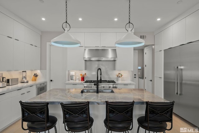 62 Caballada St, Reno, NV 89511 - kitchen featuring stainless steel built in refrigerator, wall chimney exhaust hood, modern cabinets, tasteful backsplash, and a breakfast bar area