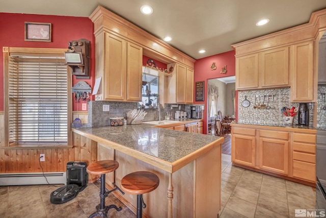 5650 S Allen Rd, Fallon, NV 89406 - kitchen featuring light brown cabinetry, tile countertops, baseboard heating, a kitchen breakfast bar, and backsplash
