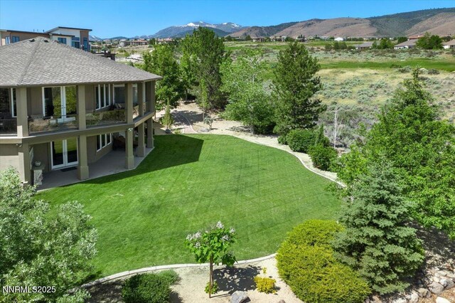 3035 Palmer Pointe Ct, Reno, NV 89511 - view of grassy yard with a mountain view, a patio area, and a balcony