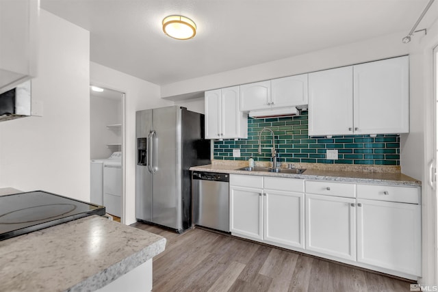 2267 Rock Blvd, Sparks, NV 89431 - kitchen with a sink, appliances with stainless steel finishes, washer and dryer, white cabinets, and light wood-style floors