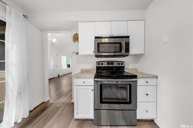 2267 Rock Blvd, Sparks, NV 89431 - kitchen featuring appliances with stainless steel finishes, white cabinets, light wood finished floors, and baseboards