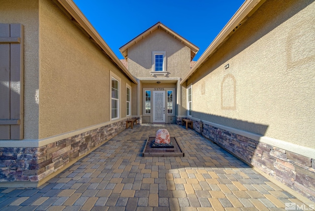 11725 Paradise View Dr, Sparks, NV 89441 - doorway to property featuring stucco siding, a patio, and stone siding