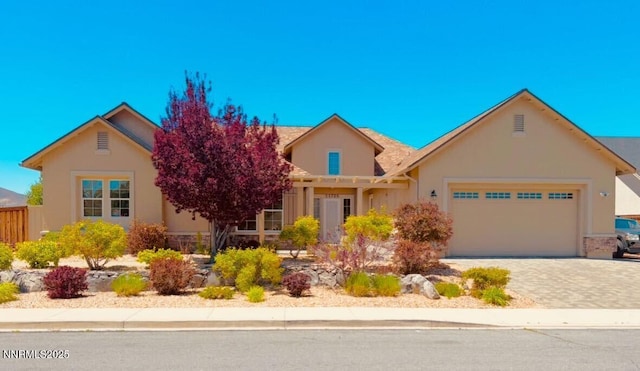 11725 Paradise View Dr, Sparks, NV 89441 - view of front of property featuring an attached garage, stucco siding, and decorative driveway