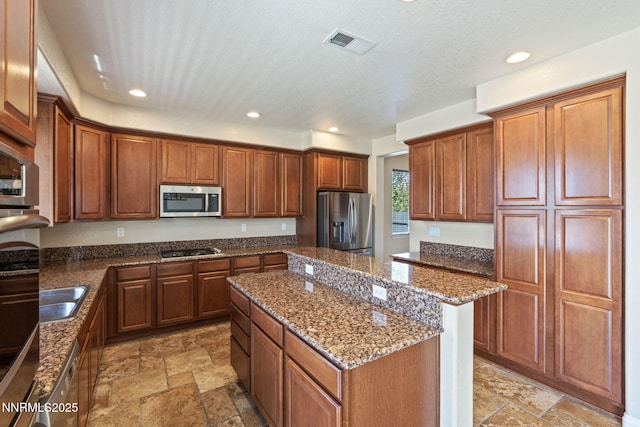 8389 Opal Ranch Way, Reno, NV 89506 - kitchen featuring stainless steel appliances, a center island, stone tile flooring, dark stone countertops, and recessed lighting