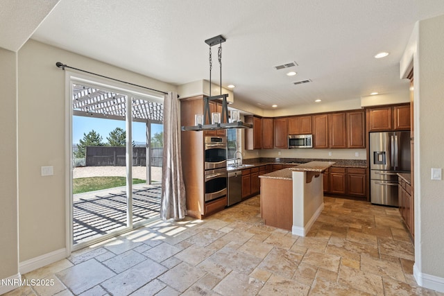8389 Opal Ranch Way, Reno, NV 89506 - kitchen with appliances with stainless steel finishes, a sink, stone tile floors, a center island, and light stone countertops