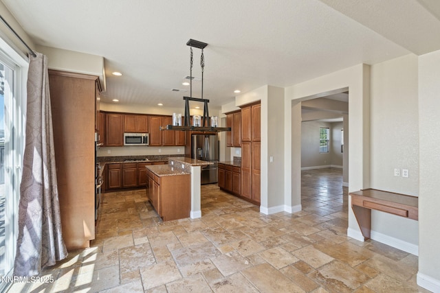 8389 Opal Ranch Way, Reno, NV 89506 - kitchen with appliances with stainless steel finishes, stone tile flooring, recessed lighting, a center island, and baseboards