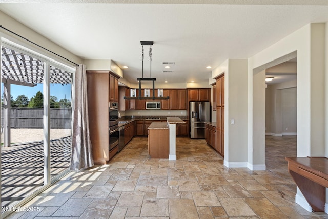 8389 Opal Ranch Way, Reno, NV 89506 - kitchen with stainless steel appliances, stone tile flooring, baseboards, decorative light fixtures, and recessed lighting