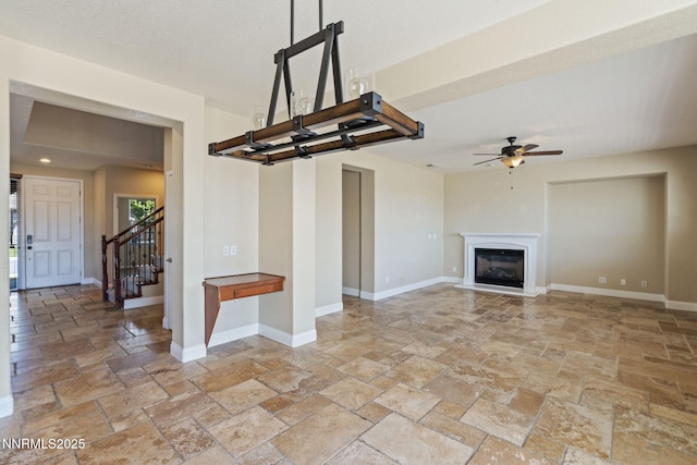8389 Opal Ranch Way, Reno, NV 89506 - unfurnished living room featuring stone tile flooring, a ceiling fan, and baseboards