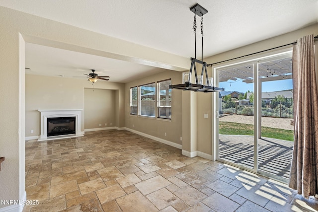 8389 Opal Ranch Way, Reno, NV 89506 - unfurnished dining area with stone tile flooring, ceiling fan, baseboards, and a fireplace with raised hearth