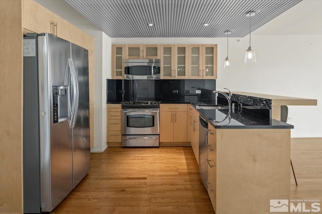 255 N Sierra St Unit 606, Reno, NV 89501 - kitchen featuring appliances with stainless steel finishes, light brown cabinetry, a peninsula, a sink, and light wood-style floors