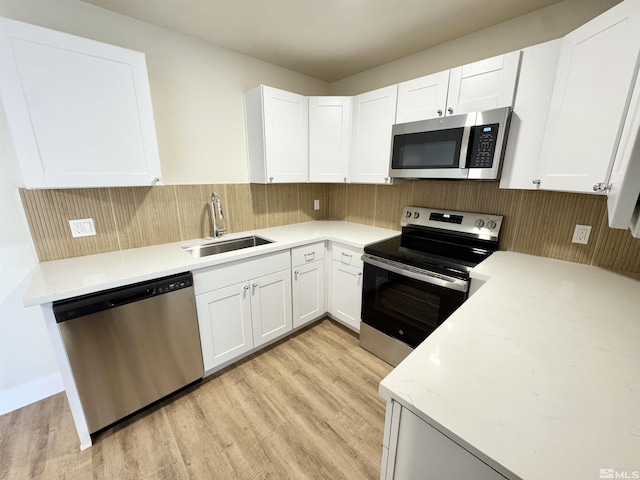2500 Tripp Dr Unit 4, Reno, NV 89512 - kitchen with appliances with stainless steel finishes, a sink, light wood-style floors, and white cabinetry