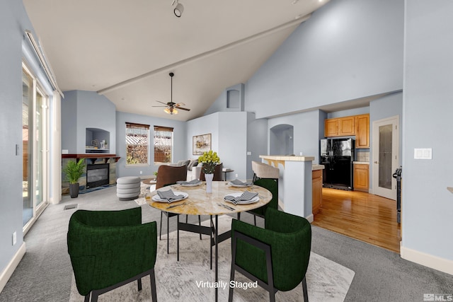 6578 Aston Cir, Sparks, NV 89436 - dining space with light carpet, a glass covered fireplace, ceiling fan, high vaulted ceiling, and baseboards