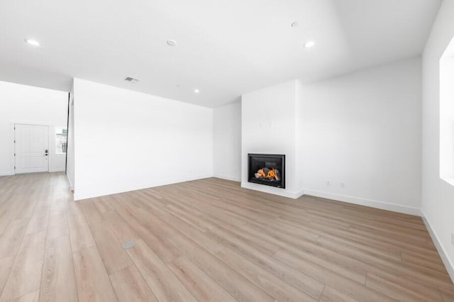 401 Pah Rah Ridge Dr Unit Harris 35, Sparks, NV 89441 - unfurnished living room featuring light wood finished floors, a warm lit fireplace, recessed lighting, and baseboards