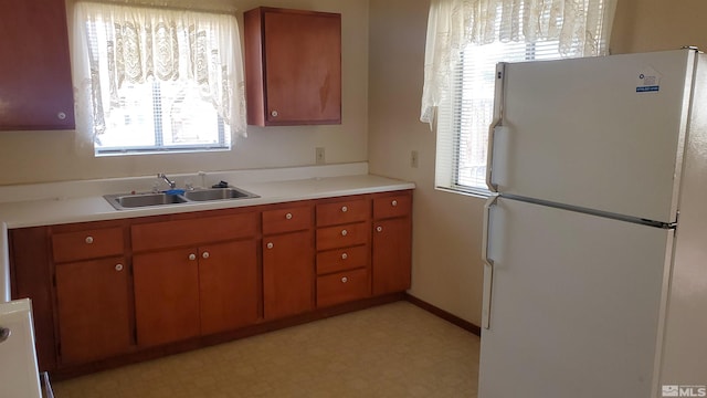 223 I St, Hawthorne, NV 89415 - kitchen with freestanding refrigerator, a sink, light floors, light countertops, and brown cabinetry