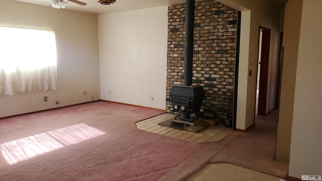 223 I St, Hawthorne, NV 89415 - unfurnished living room with carpet floors, a wood stove, ceiling fan, and baseboards