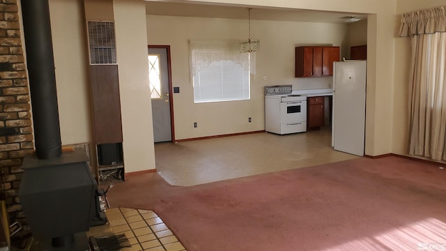 223 I St, Hawthorne, NV 89415 - kitchen featuring white appliances, a wood stove, light carpet, baseboards, and light countertops