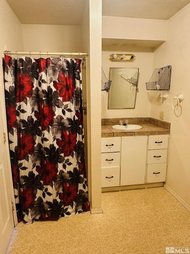815 16th St, Lovelock, NV 89419 - full bath featuring vanity, baseboards, a shower with curtain, and tile patterned floors