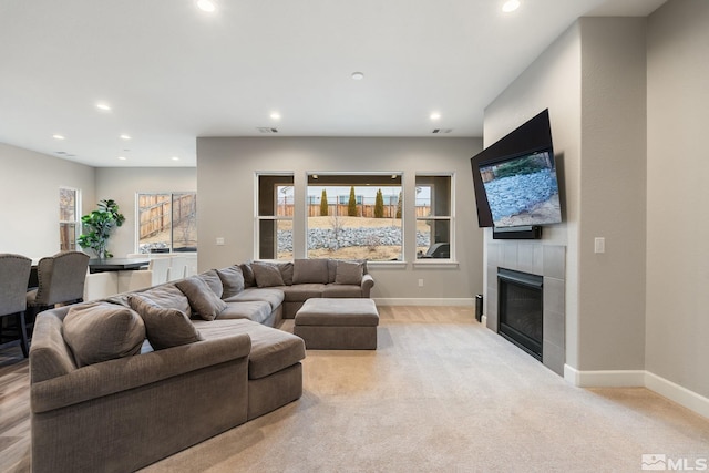 living area with recessed lighting, baseboards, a fireplace, and light colored carpet