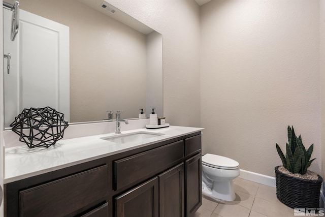 half bathroom featuring vanity, toilet, tile patterned flooring, and baseboards