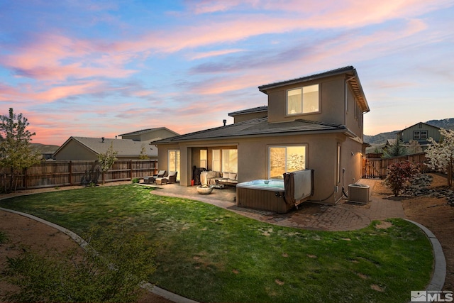 back of property with a patio, a hot tub, a tile roof, stucco siding, and an outdoor hangout area